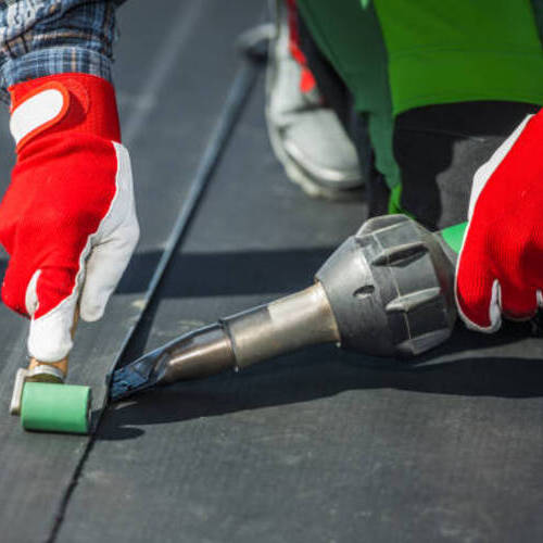 worker installing EPDM membrane roofing