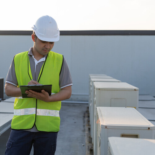 worker inspecting a commercial roof