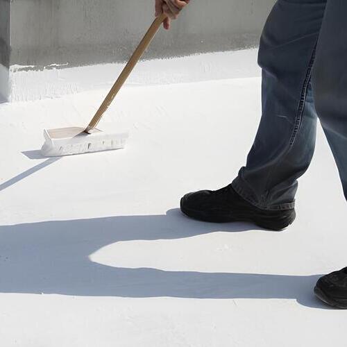worker applying a roof coating