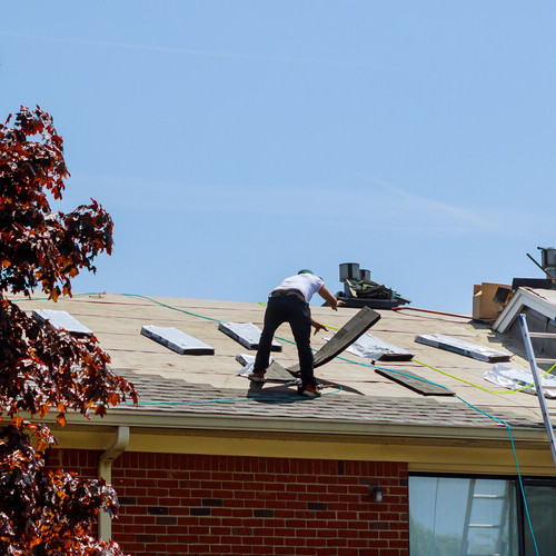 workers repairing a storm damaged roof